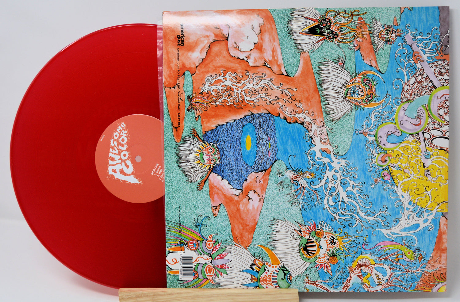 Red vinyl record with surreal fantasy-themed illustrated sleeve