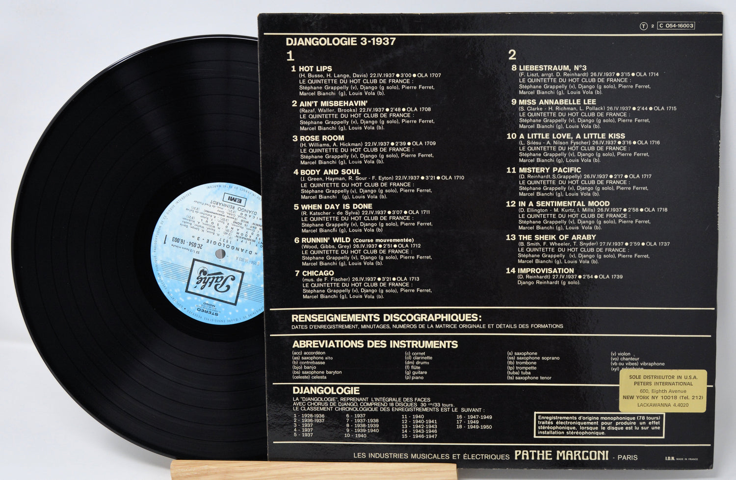 Vinyl record with cover displaying tracklist on a light gray background