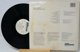 Vinyl record with cover displaying text and a logo on a white background