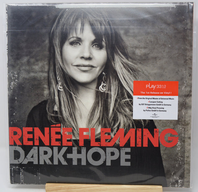 Renée Fleming's 'Dark Hope' vinyl record album cover, sealed in plastic shrink wrap with a small Play3313 sticker on the front. The cover features a black and white portrait of the artist, bold red and gray text, and a white information label.