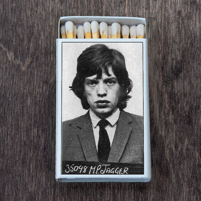 Matchbox featuring a black and white mugshot of a young man in a suit on a wooden surface