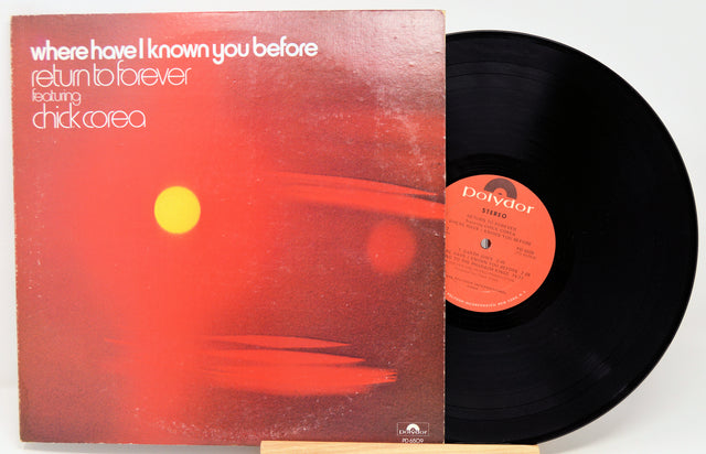 A vinyl record album shown with its cover sleeve and black record partially pulled out. The sleeve features a red abstract design with a yellow sun and white text reading 'where have i known you before / return to forever / featuring chick Corea'.
