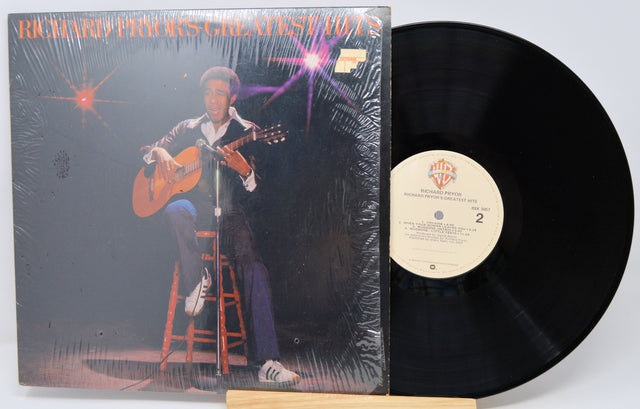 Vinyl record with cover featuring a person playing guitar on stage