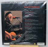 Back cover of Richard Thompson's 'Some Enchanted Evenings' 12-inch vinyl LP, sealed in plastic shrink wrap. The black cover features a photo of the singer performing live with an acoustic guitar and a track list on the right.