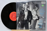 Vinyl record with a black and white cover featuring two people, one holding a guitar.