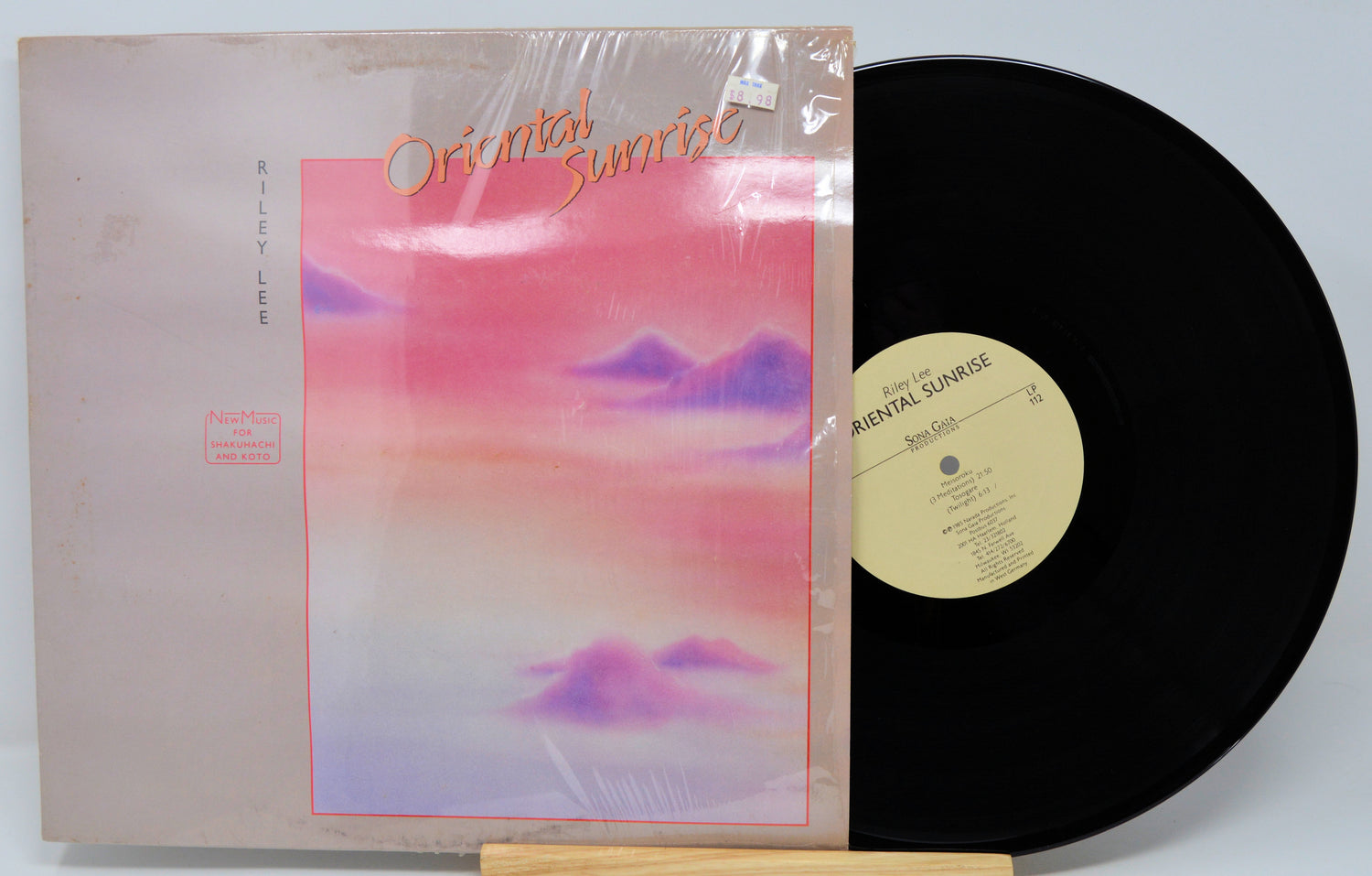 Vinyl record with a colorful cover and black disc on a light gray background