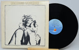 Robert Palmer 'The Sound of the World' vinyl record LP, showing the cream-colored illustrated album cover sleeve alongside the black vinyl record on a light gray background.