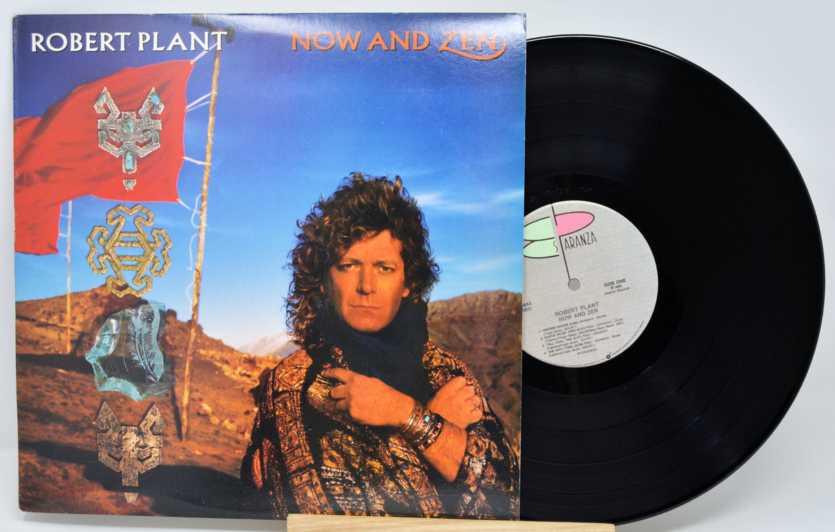 Vinyl record with cover featuring a person and decorative elements on a desert landscape.