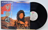 Vinyl record with cover featuring a person and decorative elements on a desert landscape.