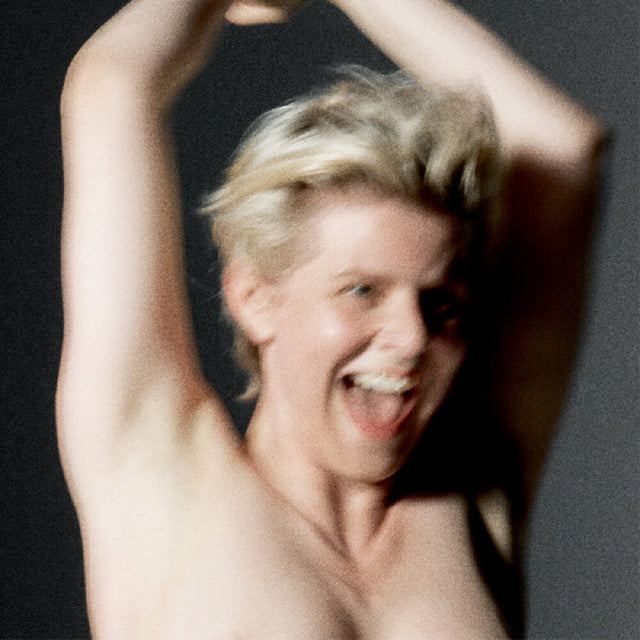 Album cover for "Sexistential' by 'Robyn' with a picture of her from the upper chest up with arms raised against a dark background