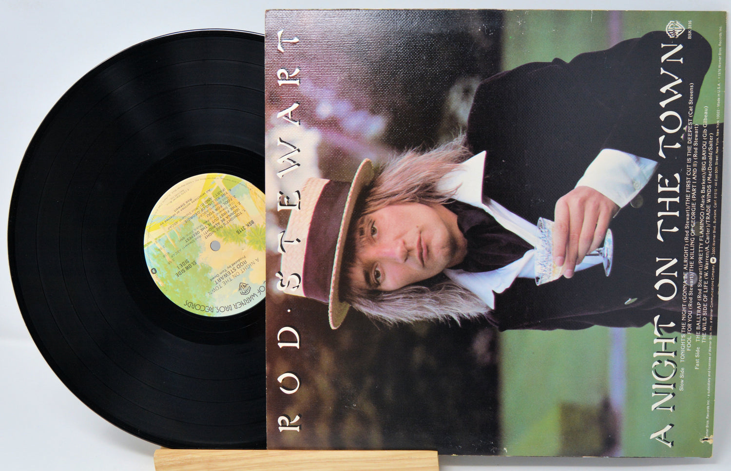 Vinyl record with cover featuring a person wearing a hat, on a light gray background