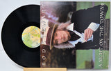 Vinyl record with cover featuring a person wearing a hat, on a light gray background