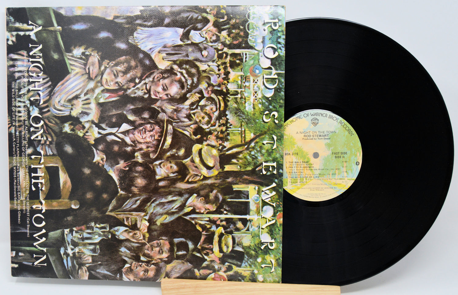 Vinyl record with a colorful cover featuring people and text, on a white background.