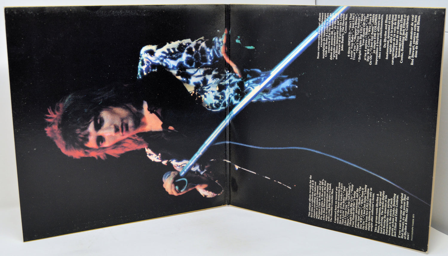 Open book or magazine with a person holding a glowing blue sword on a black background