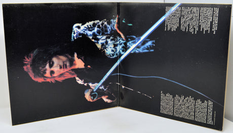 Open book or magazine with a person holding a glowing blue sword on a black background