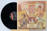 Vinyl record with a colorful album cover featuring artistic illustrations and text.