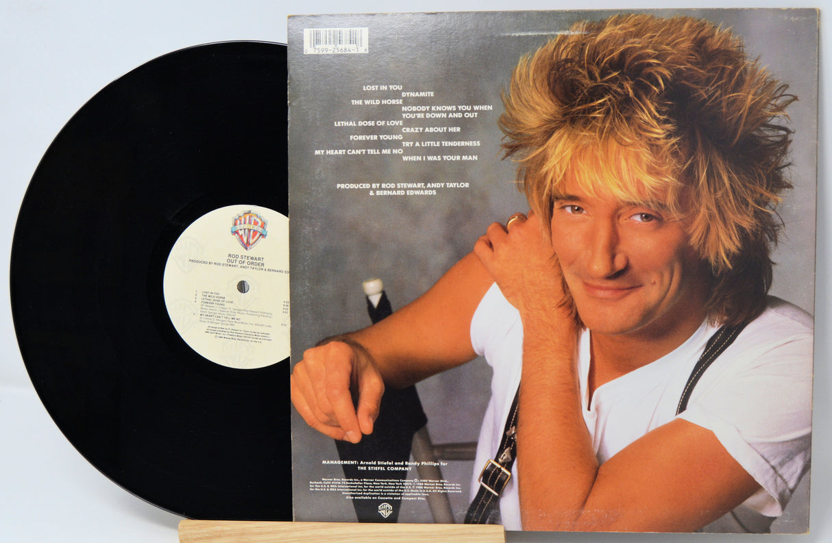 Vinyl record with a cover featuring a person holding a guitar on a light blue background