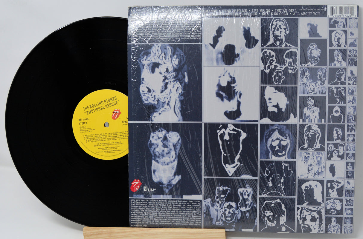 Vinyl record with a cover featuring black and white images of faces and a yellow label.