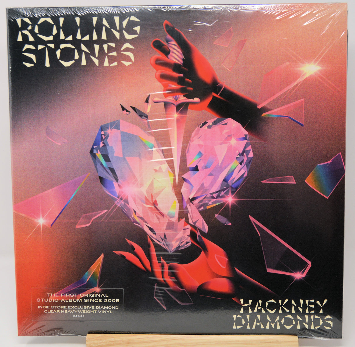 Rolling Stones 'Hackney Diamonds' vinyl record album, sealed in plastic shrink wrap and displayed on a wooden stand against a white background.