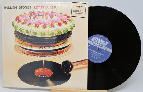 Vinyl record with cover featuring a cake illustration and 'Rolling Stones Let It Bleed' text.