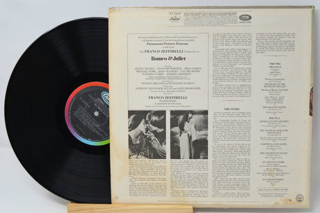 Vinyl record with cover featuring text and images on a light gray background