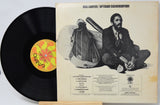 Ron Carter / Uptown Conversation vinyl record album shown with the black LP partially pulled from the cover, photographed on a white background. The cover features a black-and-white portrait of Ron Carter sitting cross-legged with a guitar, and the record label shows OVO branding.