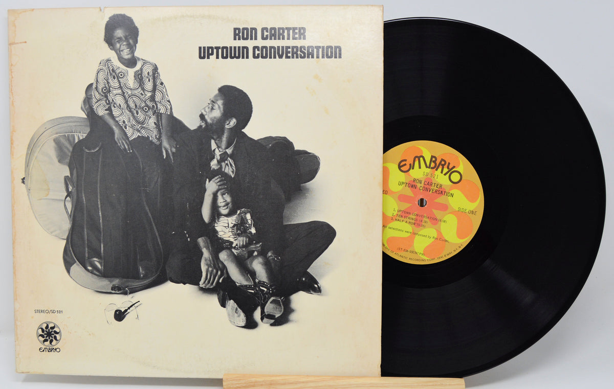 Ron Carter's 'Uptown Conversation' vinyl record LP, showing the cream-colored album cover with black-and-white cover art and the black record partially pulled out, revealing a yellow and orange 'Embryo' label.
