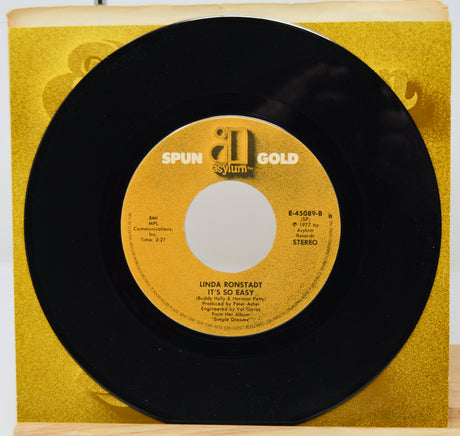 7-inch vinyl record with yellow label on a gold record sleeve