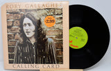 Vinyl record with cover featuring a person against a brick wall, on a light gray background.