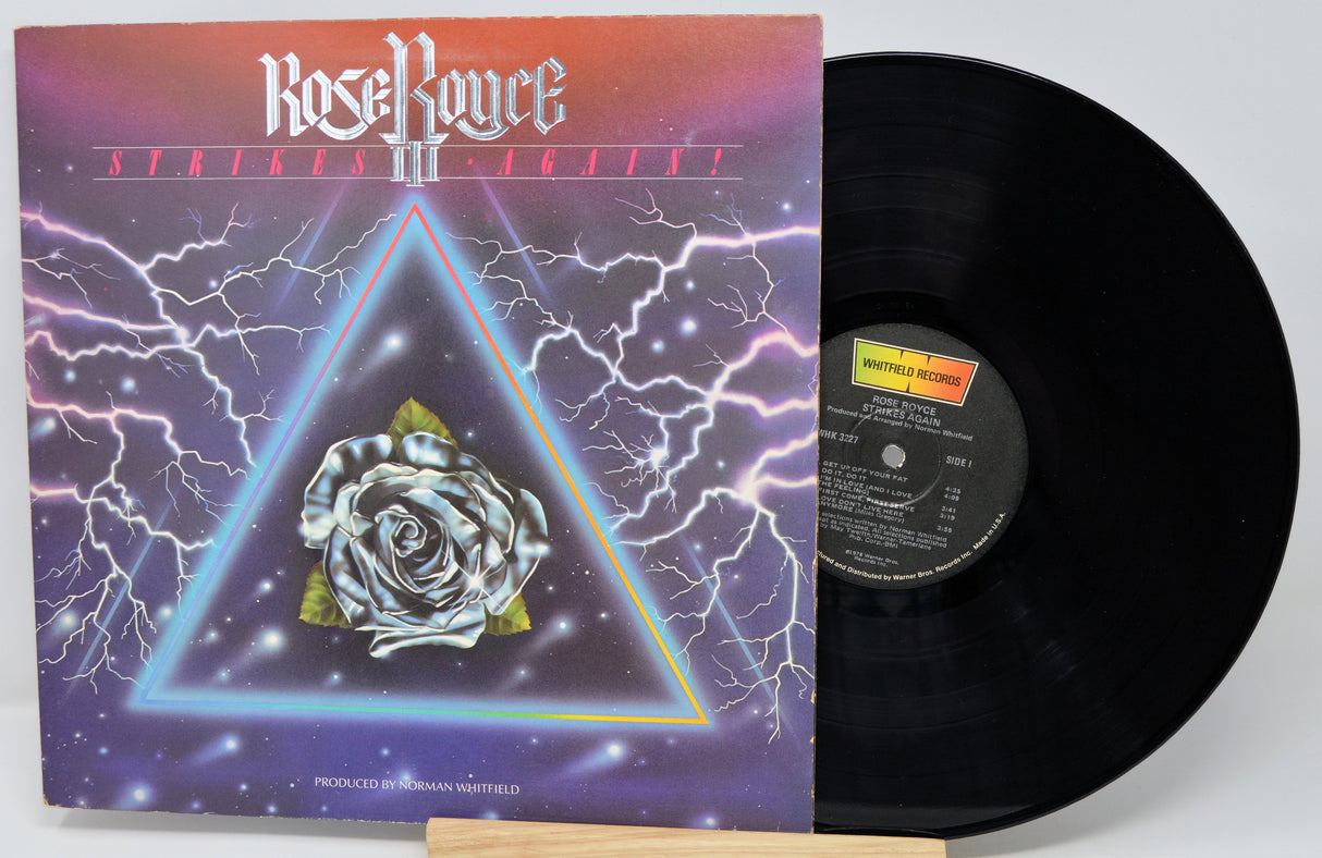 Vinyl record with cover featuring a rose and triangle design on a white background