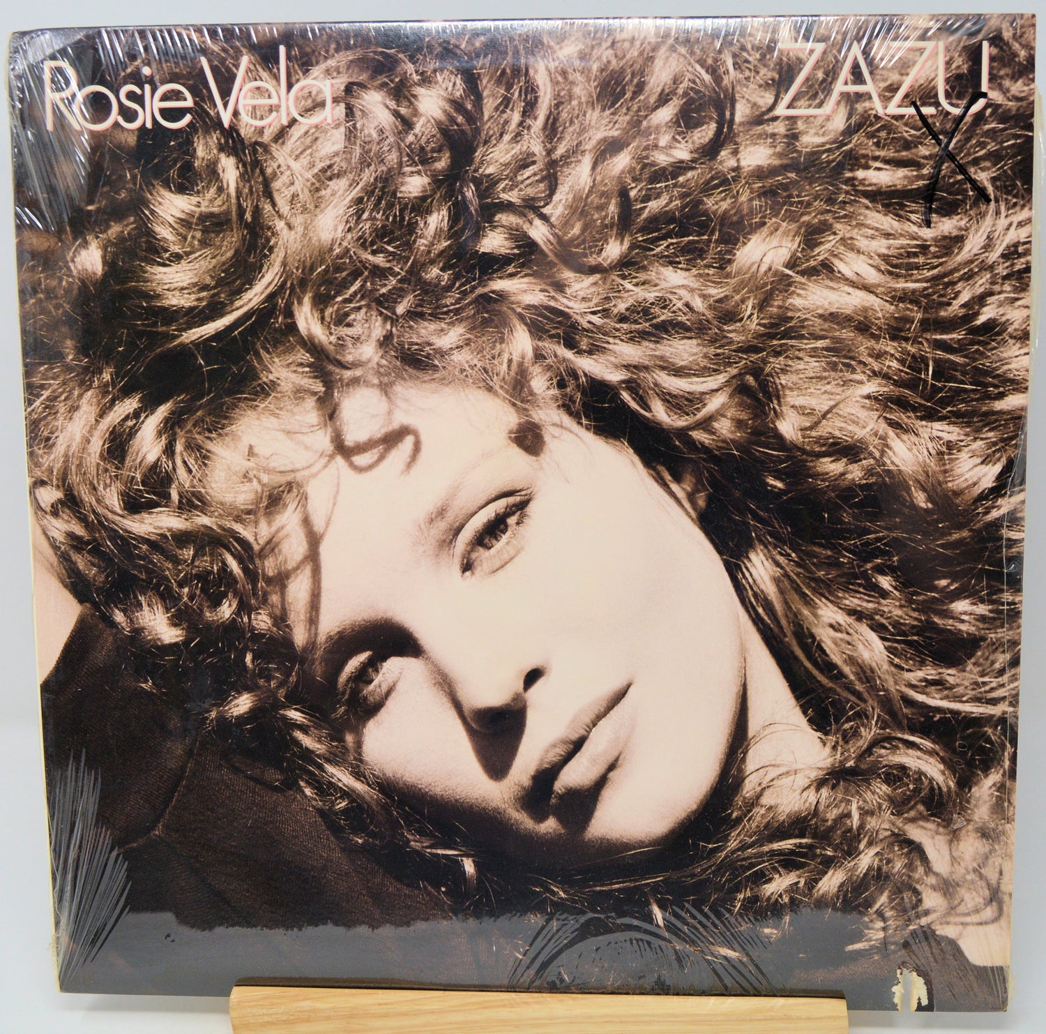 Vinyl record cover with a person's face and curly hair, featuring the name 'Rosie Vela'.