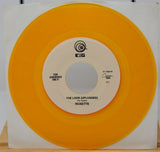 Vinyl record with orange outer sleeve and white inner label on a wooden surface