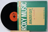 Vinyl record with green cover featuring 'Roxy Music' and 'Jealous Guy' text.
