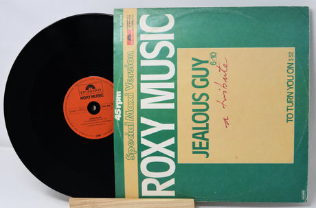 Vinyl record with green cover featuring 'Roxy Music' and 'Jealous Guy' text.