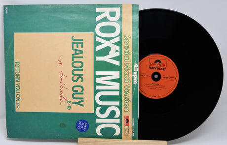 Vinyl record with green cover featuring 'Roxy Music' and 'Jealous Guy' text on a white background