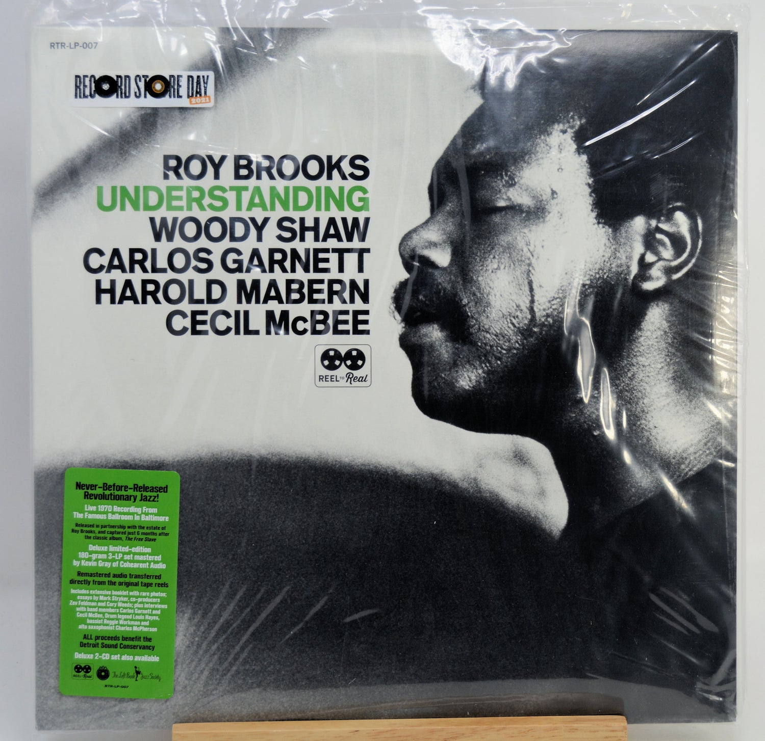A vinyl record sleeve for Roy Brooks' album 'Understanding' on the label Store Day / We're All Goin' Down, shown wrapped in clear plastic with a green sticker on the lower left. The cover features a black-and-white portrait of Roy Brooks and black text on a light background.