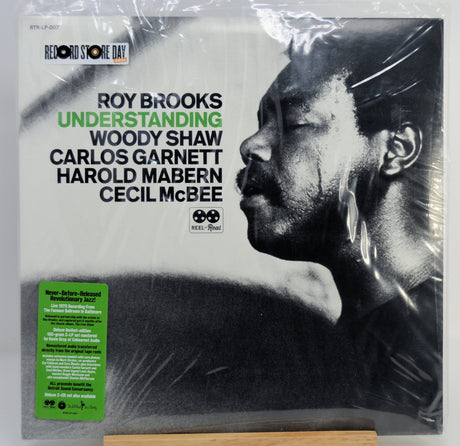 A vinyl record sleeve for Roy Brooks' album 'Understanding' on the label Store Day / We're All Goin' Down, shown wrapped in clear plastic with a green sticker on the lower left. The cover features a black-and-white portrait of Roy Brooks and black text on a light background.