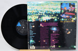Vinyl record with colorful cover featuring text and a small image of a person.