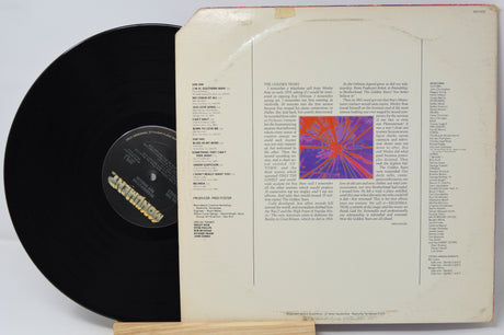 Vinyl record with cover featuring text and a colorful abstract design on a white background
