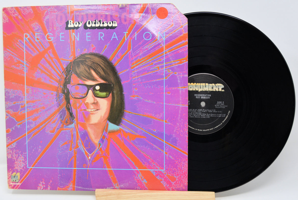 Vinyl record with a colorful cover featuring a person wearing sunglasses, on a white background.
