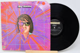 Vinyl record with a colorful cover featuring a person wearing sunglasses, on a white background.