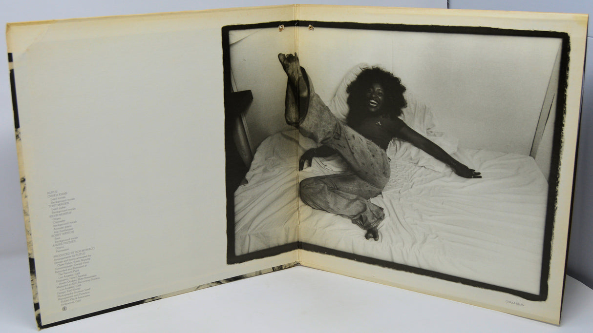 Open book with a black and white photograph of a person on a bed inside.