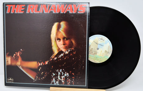 Vinyl record with cover featuring a woman holding a guitar, titled 'The Runaways'.