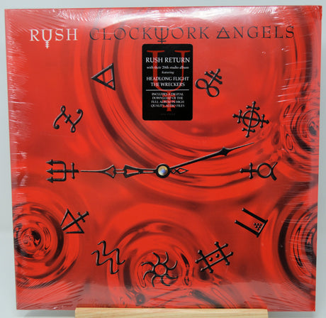 Rush 'Clockwork Angels' vinyl record album cover displayed flat, wrapped in protective plastic with a cardboard insert visible at the bottom.