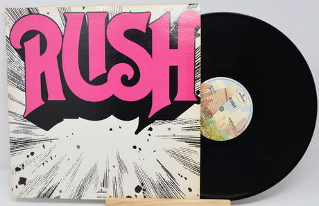 Vinyl record with 'Rush' album cover featuring pink text on a white background
