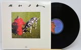 A vinyl record partially pulled from its sleeve, showing the album cover artwork and the black record disc on a light background.