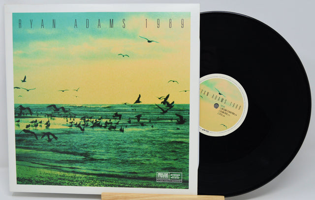 Vinyl record with cover featuring a scenic design and 'Ryan Adams 1989' text.