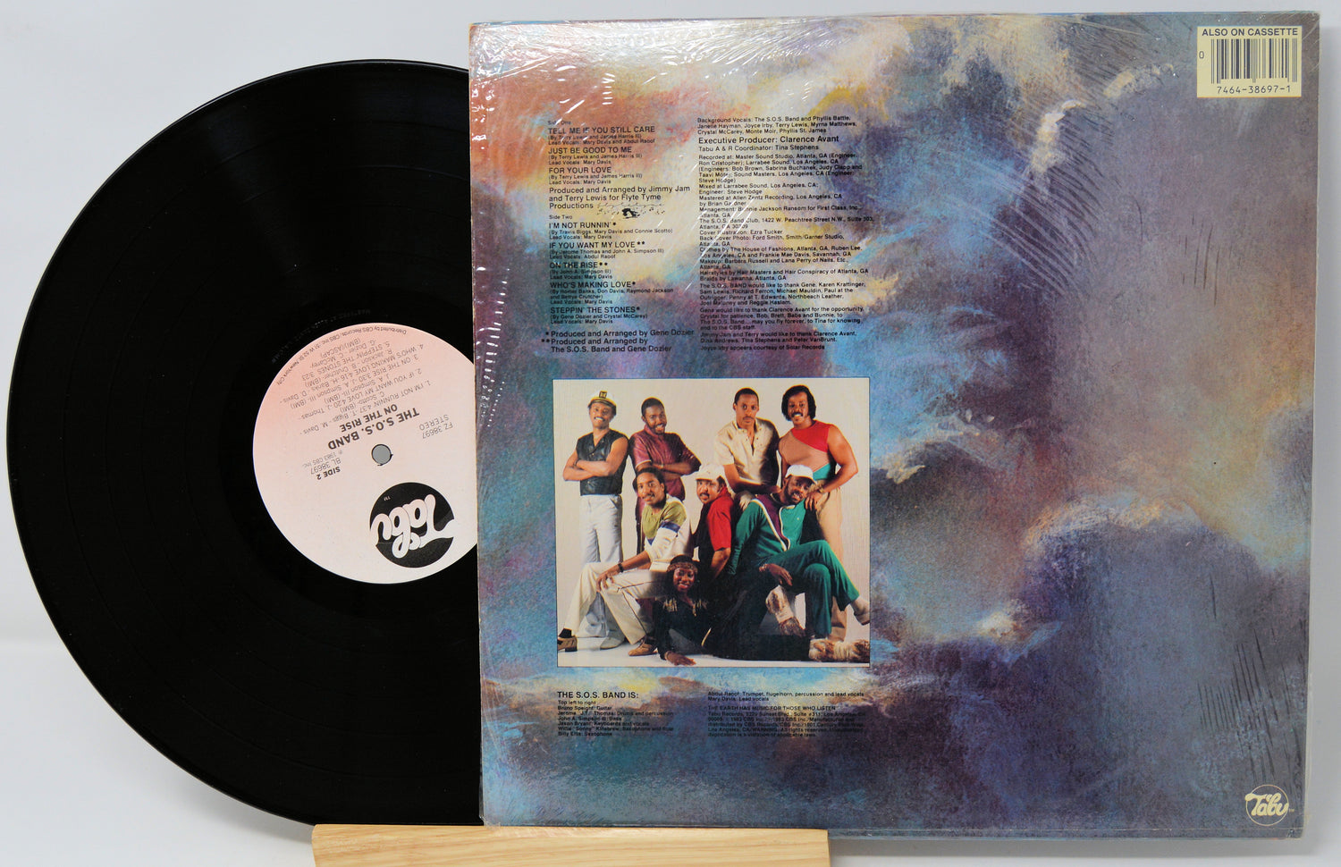 Vinyl record with cover featuring a group of people against a colorful abstract background