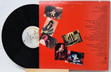 Vinyl record with a red cover featuring black and white images of a band on a white background