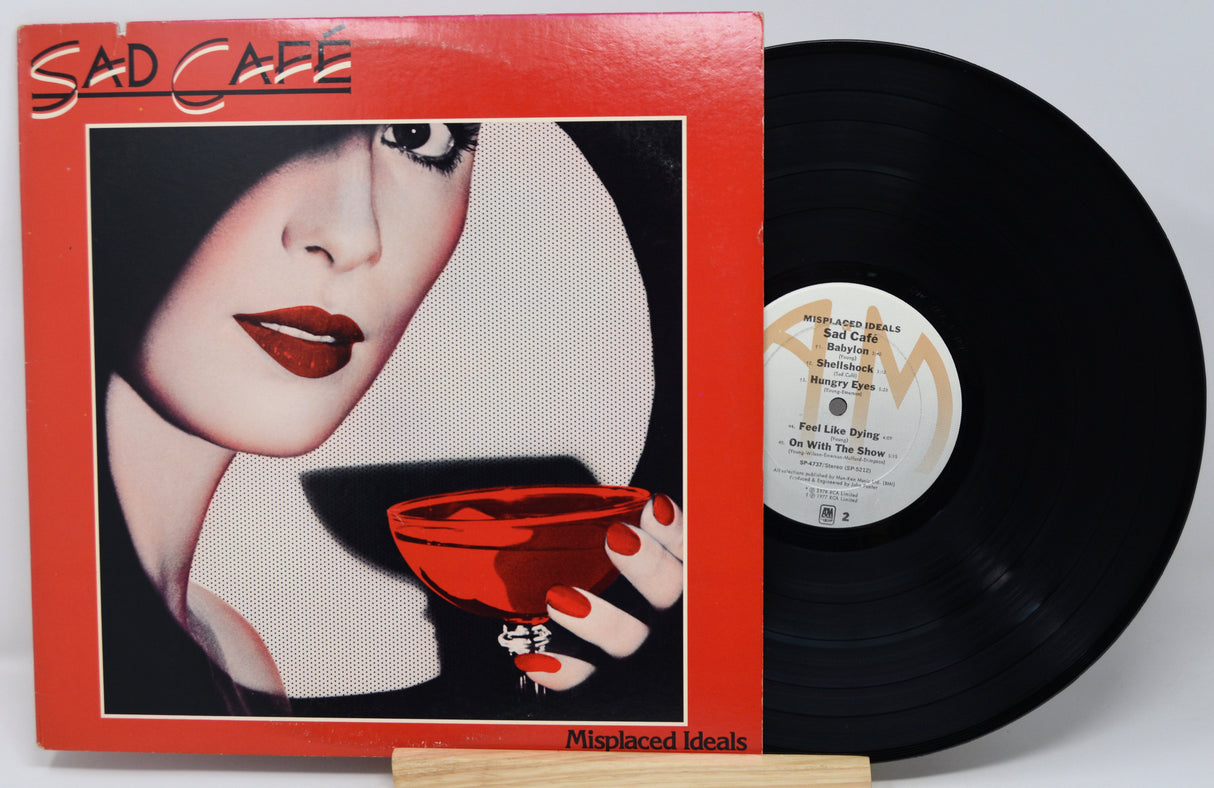 Vinyl record with a cover featuring a woman's face and a red cup, labeled 'Sad Cafe'.